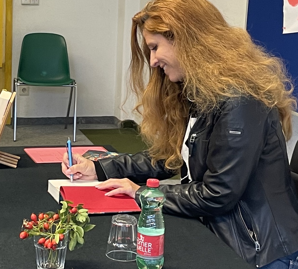 Ursula Poznanski signiert Bücher bei ihrer Lesung am BG und BRG Perchtoldsdorf im September 2022.